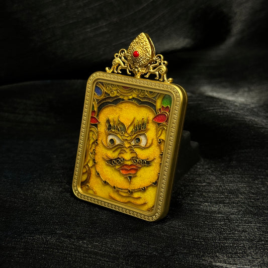 Angled view of Yellow Jambhala mini thangka pendant crafted with cloisonné enamel and 24K gold-plated copper frame, highlighting raised enamel patterns and Tibetan ornamental details.