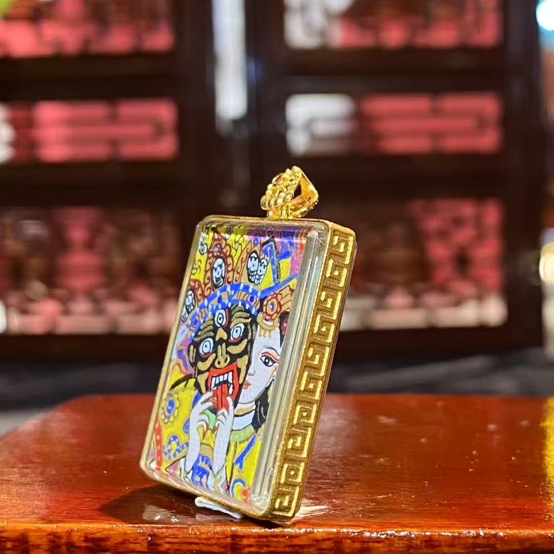 Side view of an 18K gold Tibetan Ghau Thangka pendant showing handcrafted Ghau case and sapphire crystal glass