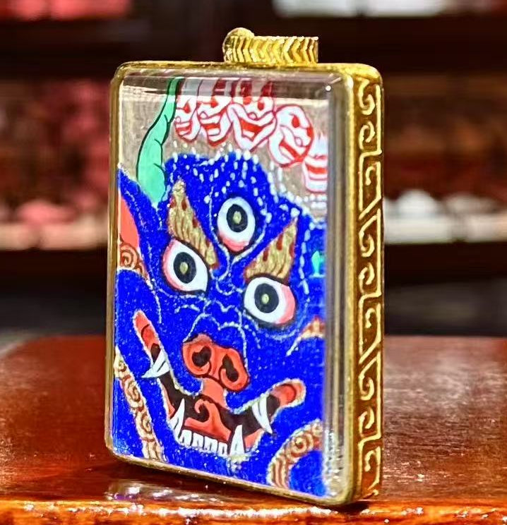 Side view of 18K gold Gau box thangka pendant showing sapphire crystal protection and compact craftsmanship details