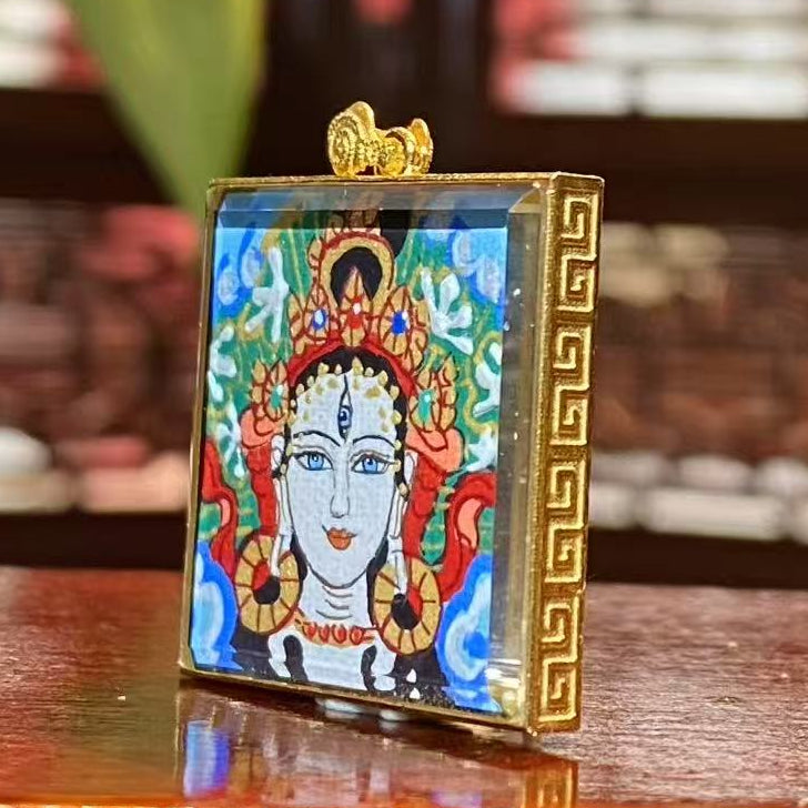 Side view of 18K gold gau box Tibetan thangka pendant with double sapphire crystal lenses and hand-painted artwork