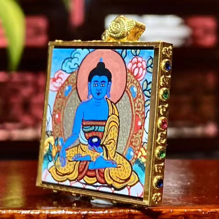 Side view of 18K gold gau box Tibetan thangka pendant with sapphire crystal lens and hand-painted Medicine Buddha artwork