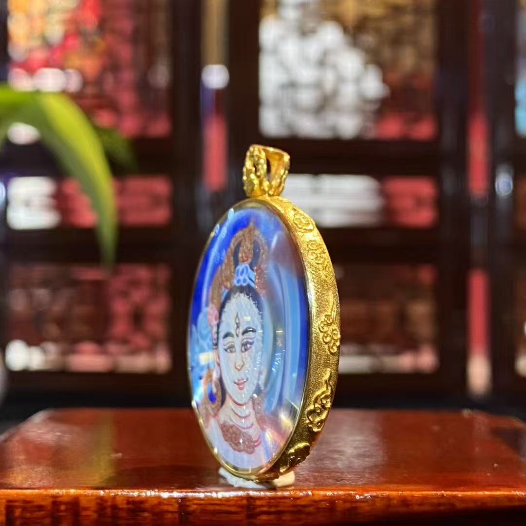 Side view of 18K gold gau box Tibetan thangka pendant with sapphire crystal lens and hand-painted White Tara artwork