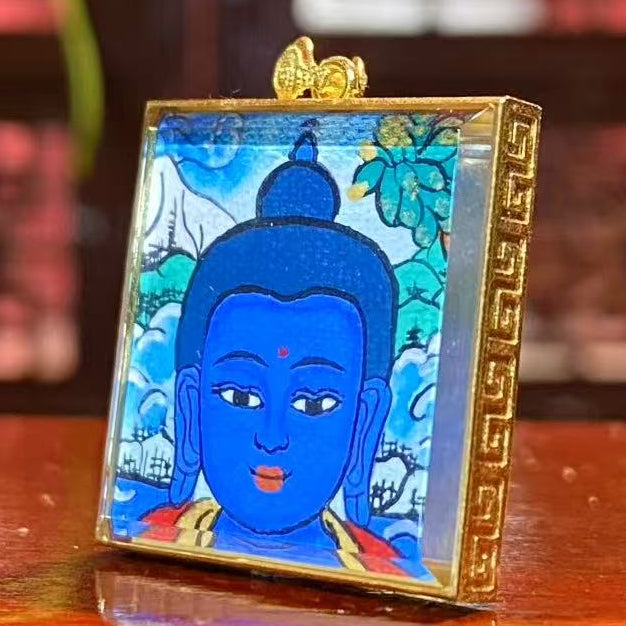 Side view of 18K gold gau box Tibetan thangka pendant with sapphire crystal lens and hand-painted Medicine Buddha artwork