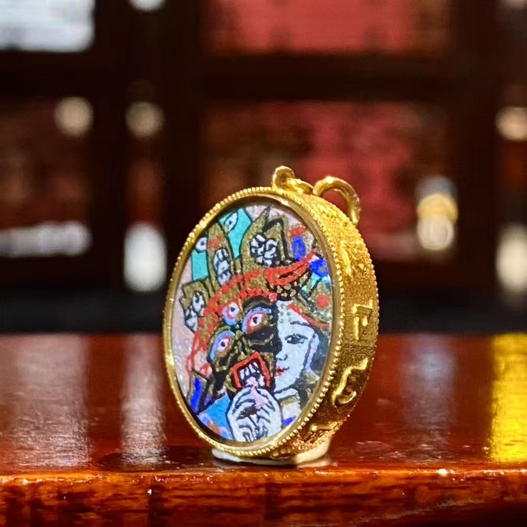 Side view of an 18K gold round Tibetan Ghau Thangka pendant showing handcrafted case and sapphire crystal glass