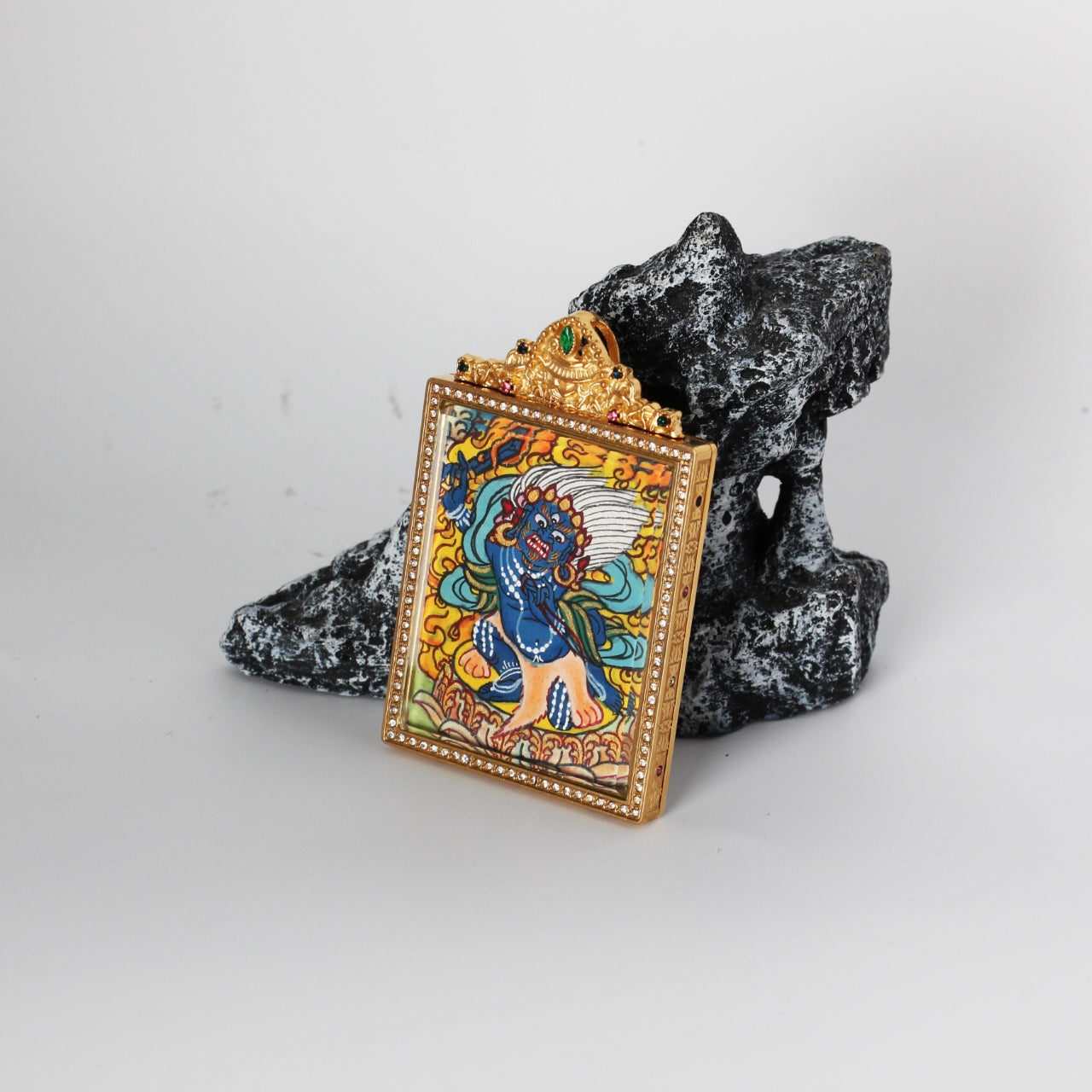 Front view of Acalanatha (Fudo Myo-o) mini thangka pendant highlighting the hand-painted deity image, crystal-set border around the frame, and the ornate crown top with green and multicolor stones.