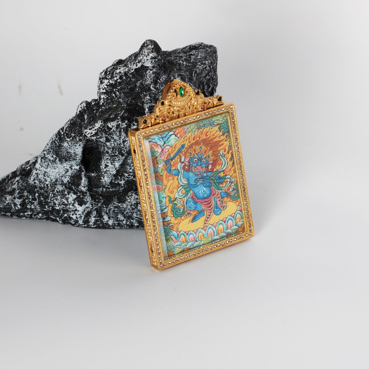 Side detail of Acalanatha (Fudo Myo-o) mini thangka pendant highlighting double-sided construction, metal edge finishing, and crystal-style border detailing around the frame