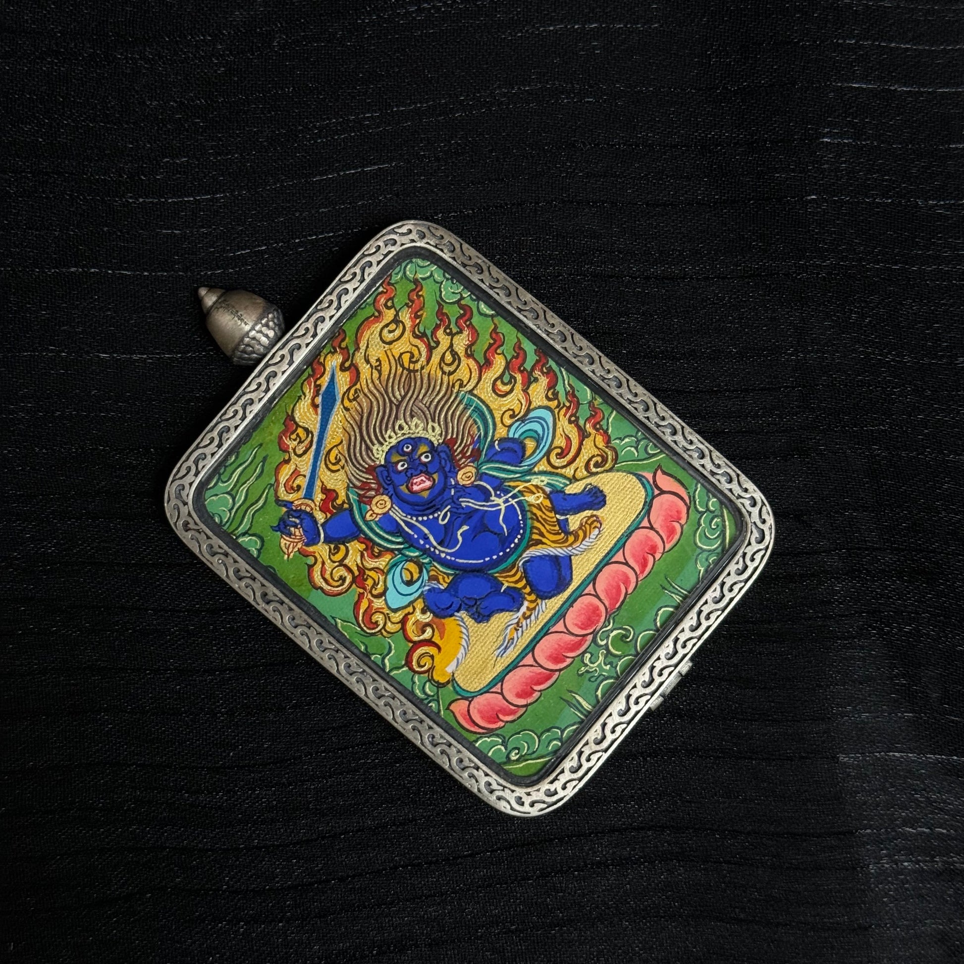 Top view of Acalanatha (Fudo Myo-o) miniature thangka pendant depicting the fierce protector deity surrounded by flames in traditional Buddhist iconography.