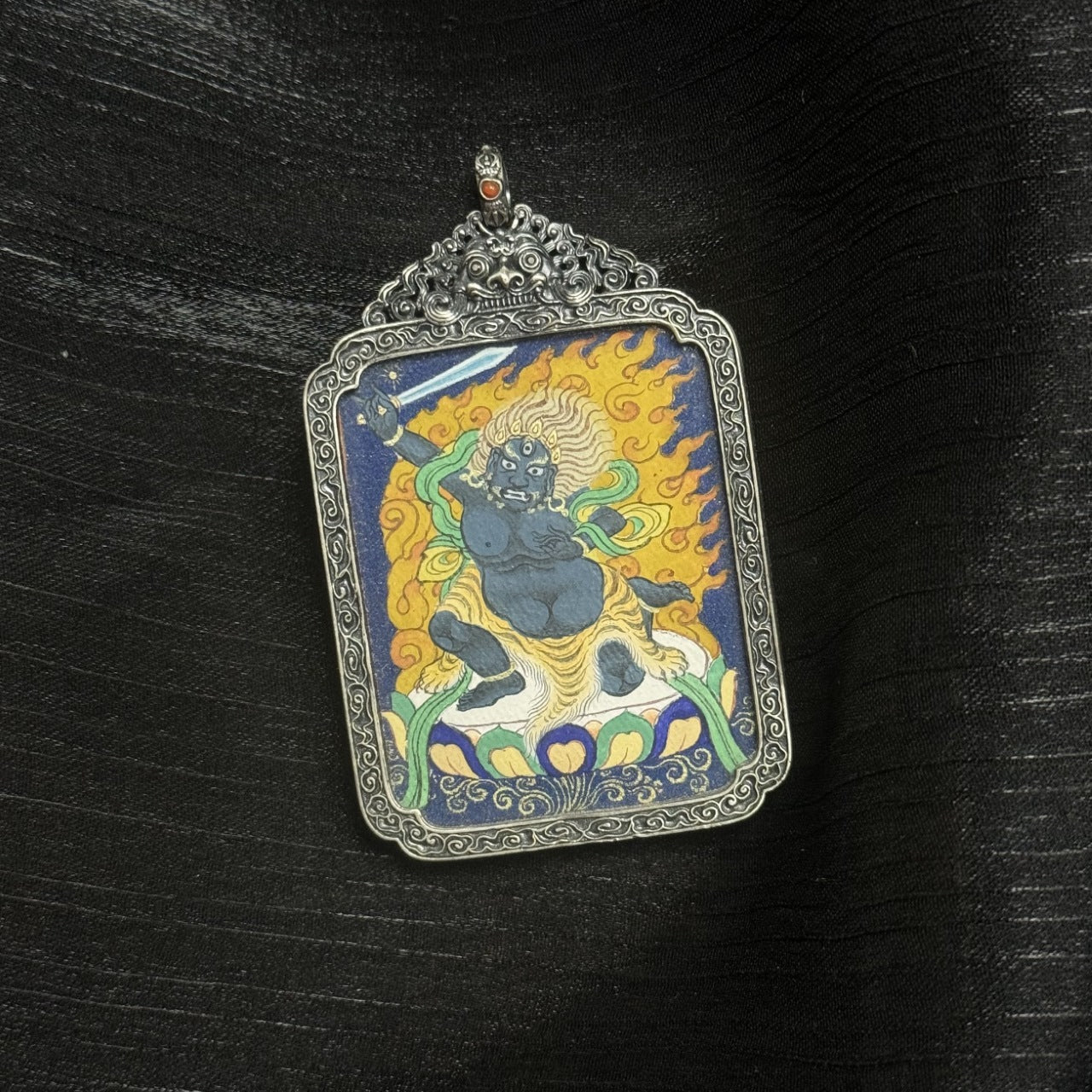 Full view of Acalanatha mini thangka pendant, hand-painted in Tibet using mineral pigments, enclosed in an ornate vintage silver frame.