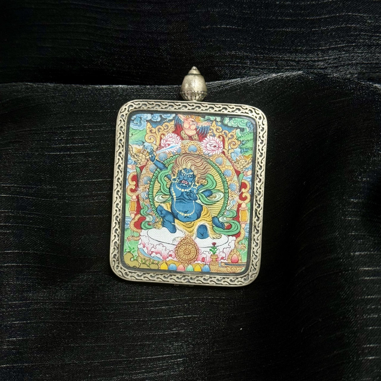 Front view of a hand-painted Acalanatha (Fudo Myo-o) mini thangka pendant set in a Dunhuang Nine-Color Deer silver gawu case, featuring mineral pigment layers, flame halo background, and detailed wrathful deity iconography.