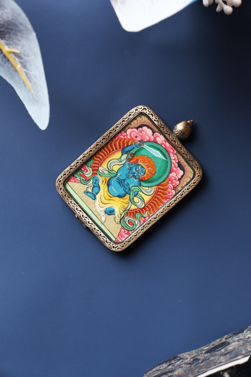Front view of Acalanatha (Fudo Myo-o) mini thangka pendant, hand-painted with mineral pigments, set in a Tibetan silver gawu-style case