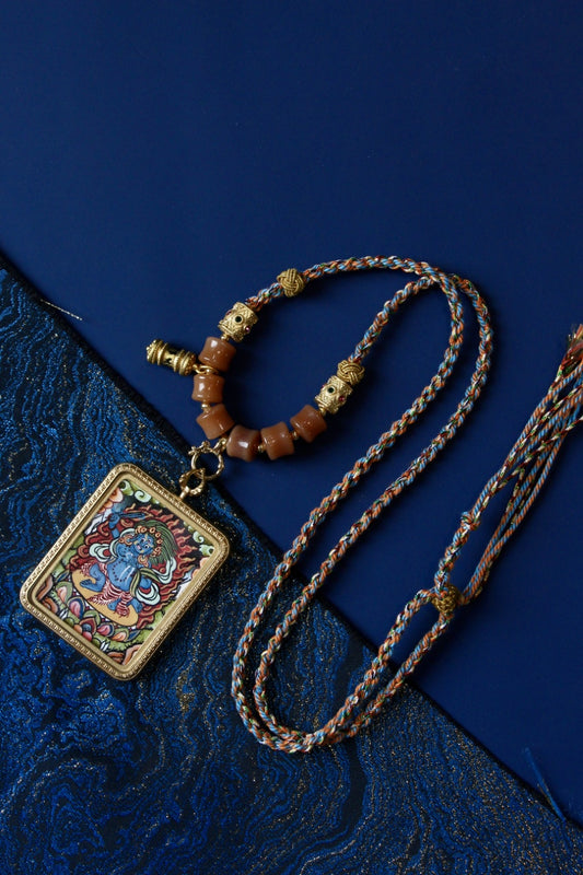 Mini thangka necklace of Acalanatha (Fudo Myo-o) in traditional Nepal Newar style, featuring mineral pigments, braided cord, and titanium steel frame for spiritual protection.