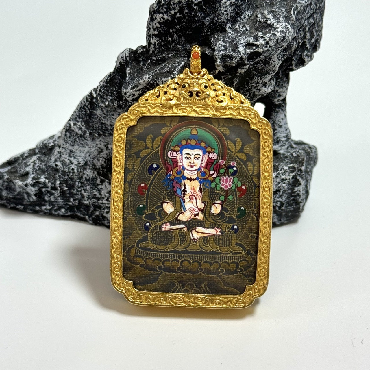 Front view of Akasagarbha Bodhisattva mini thangka pendant, hand-painted with mineral pigments in Nepal black gold style, gold detailing on dark ground, mounted in an ornate copper protective case