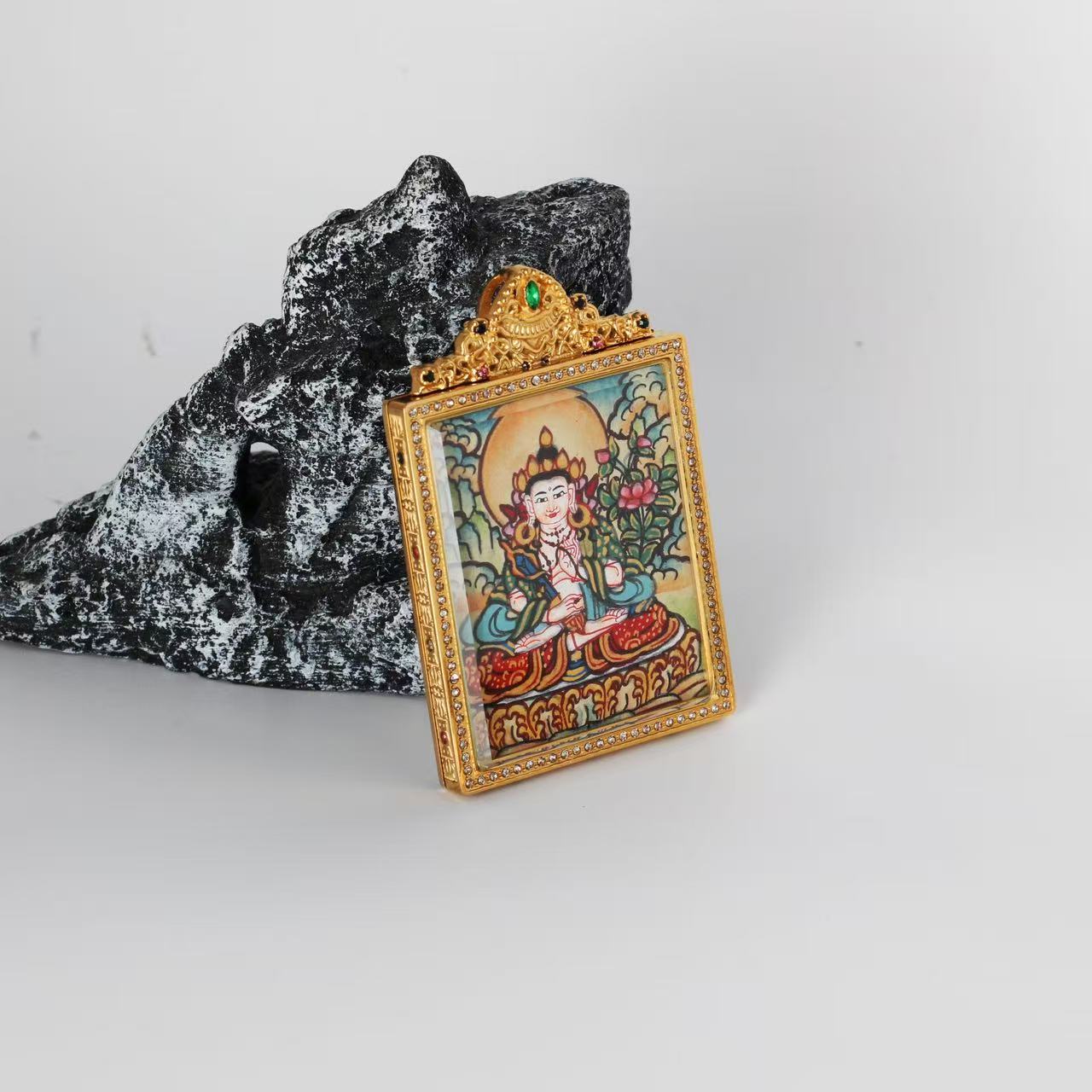 Angled view of the Akashagarbha Bodhisattva mini Thangka pendant, highlighting the thickness of the double-sided titanium steel case and the decorative jewel-set frame.