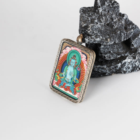 Angled view of an Akashagarbha Bodhisattva mini Thangka pendant, fully hand-painted with mineral pigments and mounted in a pure silver gawu-style pendant case featuring traditional Tibetan decorative patterns.