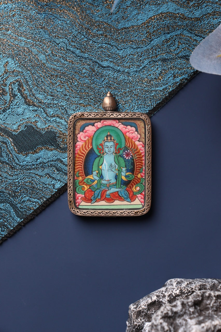 Close-up view of the hand-painted Akashagarbha Bodhisattva mini thangka pendant, showing detailed mineral pigment colors and traditional Tibetan iconography