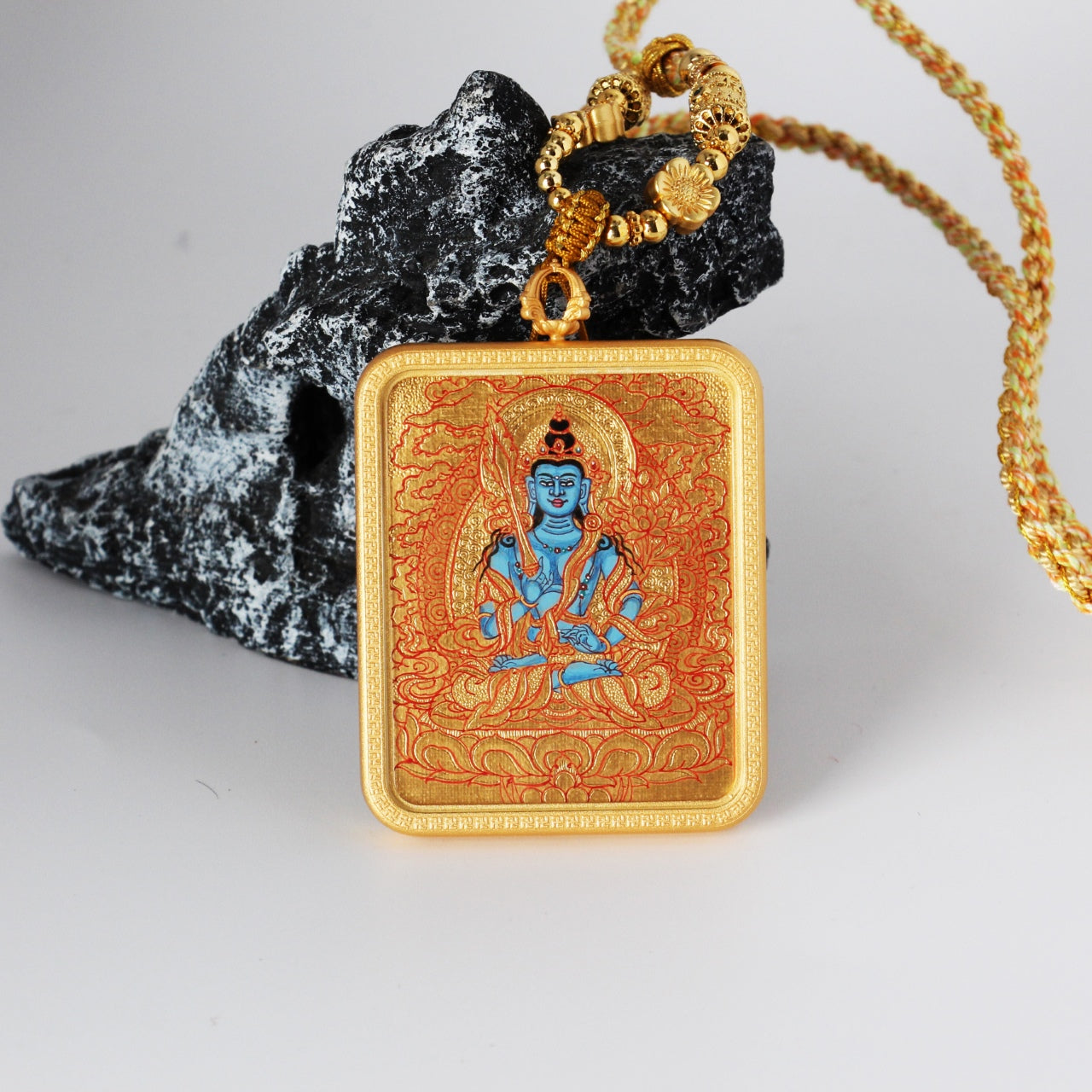 Front view of an Akashagarbha Bodhisattva mini thangka pendant featuring a blue deity figure, fine red line work on a gold-ground background, hand-painted with mineral pigments and set in a copper case.