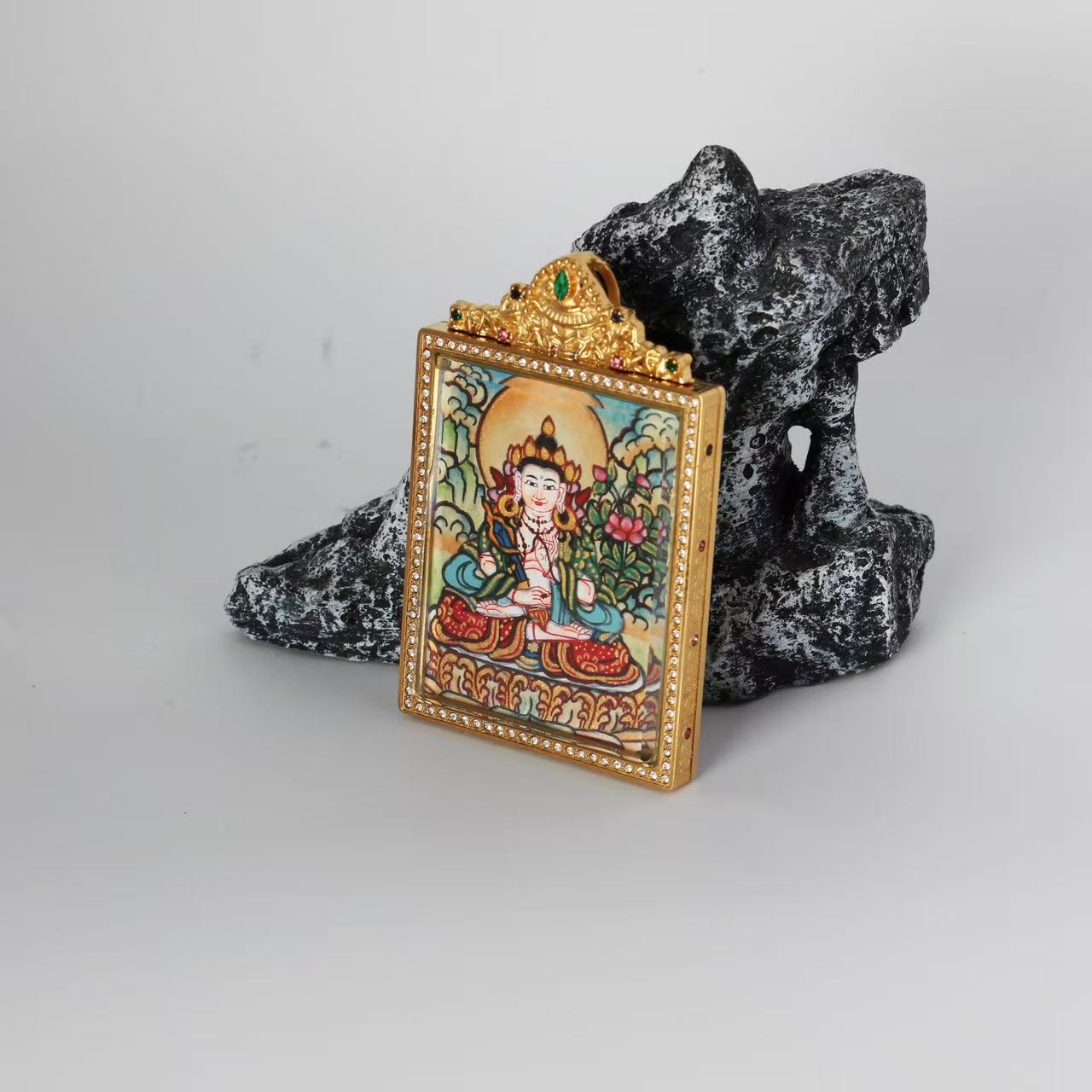 Side view of an Akashagarbha Bodhisattva mini Thangka pendant, showing the layered construction, double-sided format, and sculpted top ornament of the jewelry-style case.