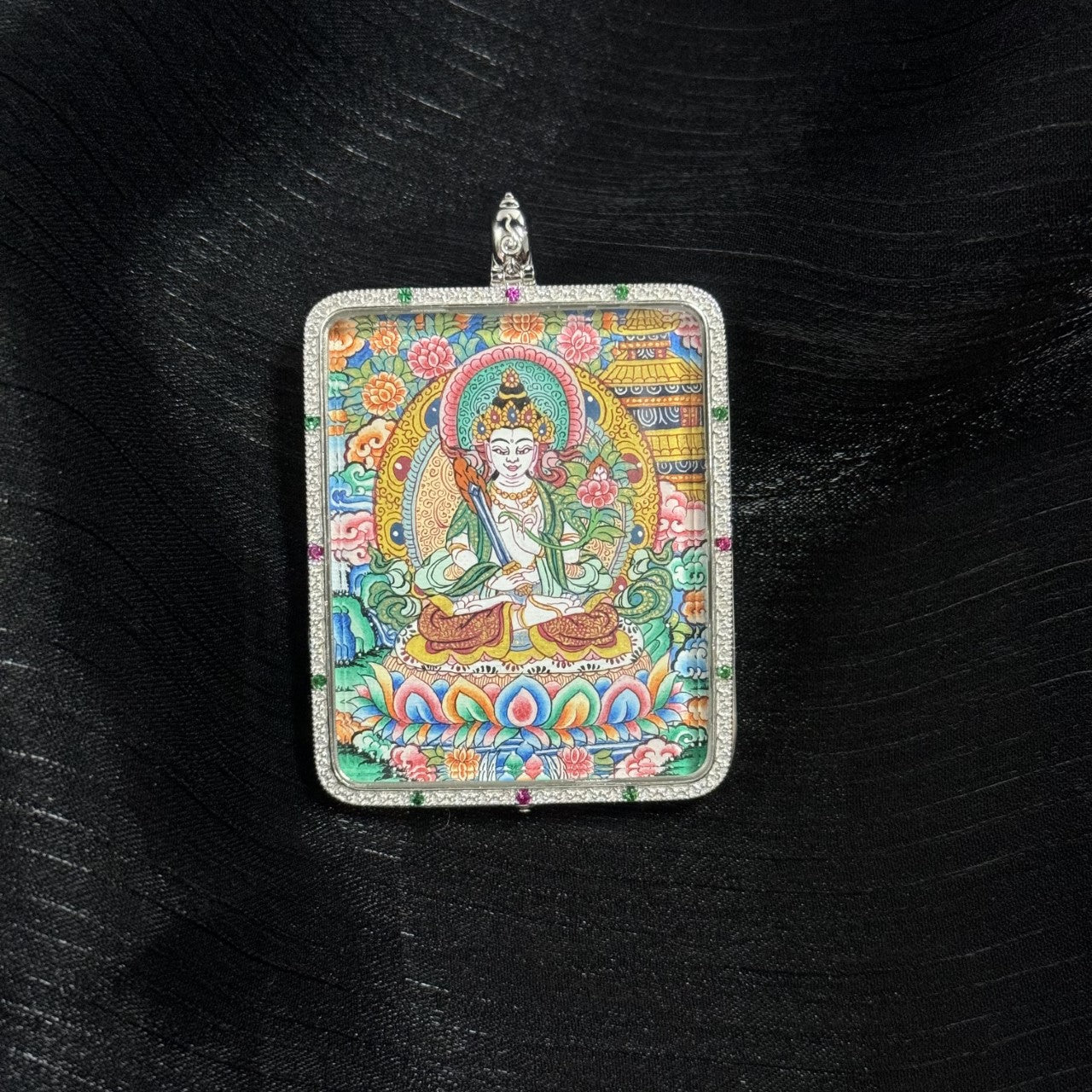 Angled view of Akashagarbha Bodhisattva mini thangka pendant highlighting the mineral pigment painting, colorful lotus base, and decorative 925 silver gemstone pendant frame.