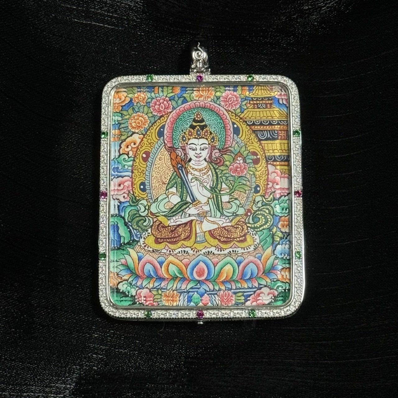 Close-up of Akashagarbha Bodhisattva thangka pendant showing fine hand-painted facial features, lotus throne, floral background, and intricate Tibetan decorative motifs.