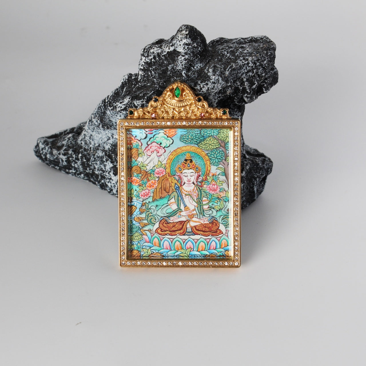Front view of Akashagarbha Bodhisattva depicted on a mini thangka pendant, framed in gold with crystal-like stones and ornate top detail.