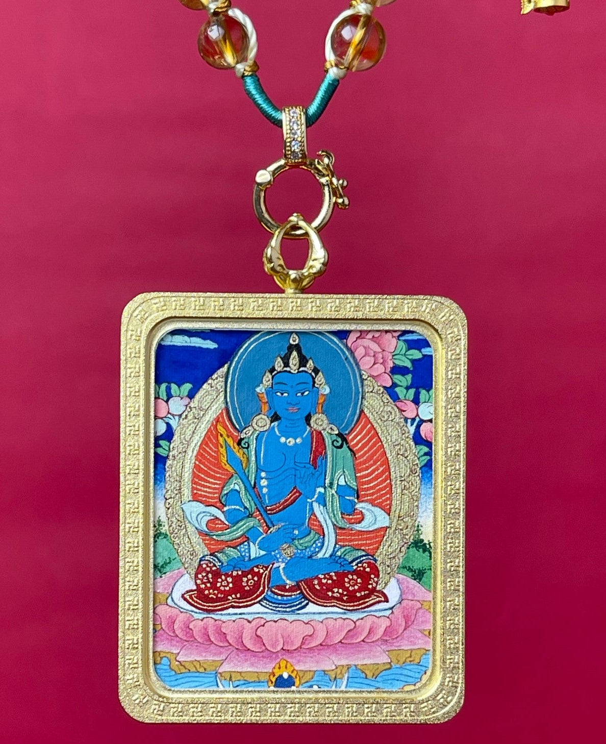 Hand-painted Akashagarbha Bodhisattva Tibetan Thangka pendant with mineral pigments, gold-tone frame, front view