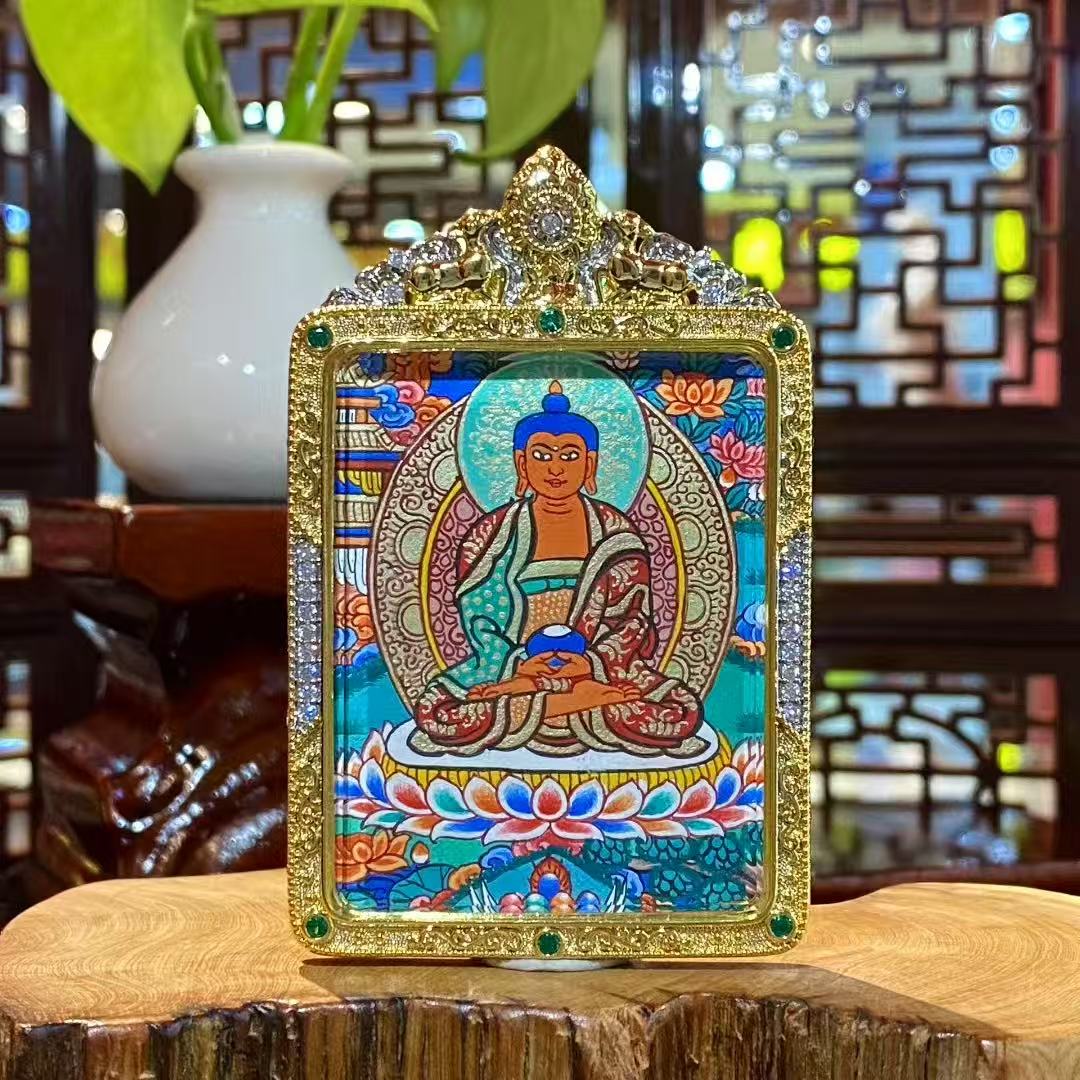 Front view of hand-painted Amitabha Buddha thangka in a gold-plated copper Gau pendant, showing a seated Buddha on a lotus throne with halo, clouds, and Pure Land motifs