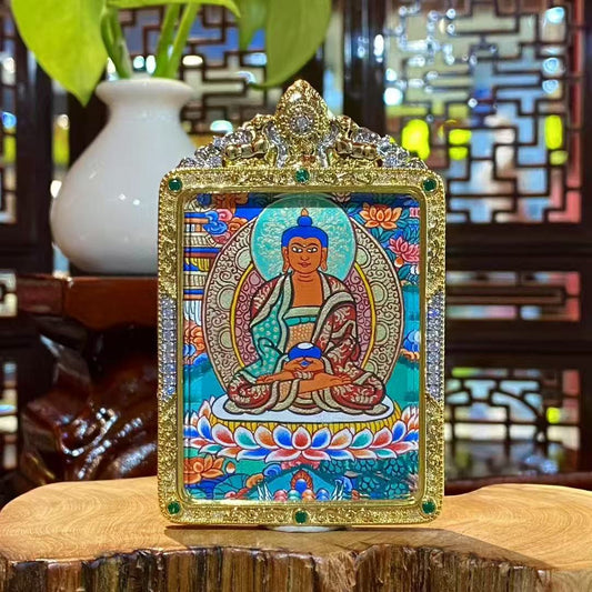 Front view of hand-painted Amitabha Buddha thangka in a gold-plated copper Gau pendant, showing a seated Buddha on a lotus throne with halo, clouds, and Pure Land motifs