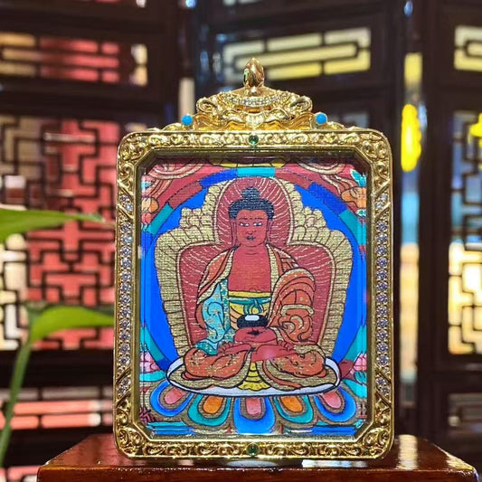 Front view of hand-painted Amitabha Buddha thangka in a gold-plated copper Gau pendant, showing a seated Buddha with lotus throne, halo, and vivid traditional iconography