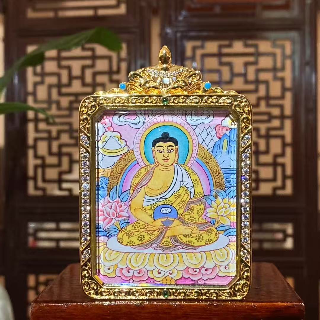 Front view of hand-painted Amitabha Buddha thangka in a gold-plated copper Gau pendant, showing a seated Buddha with lotus throne, halo, and vivid traditional iconography
