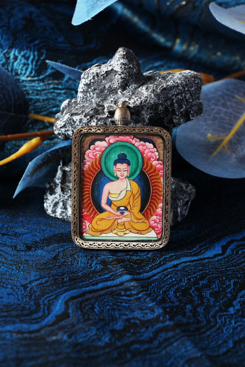 Close-up product photo of the Amitabha Buddha mini thangka pendant highlighting hand-painted mineral pigment craftsmanship and the sterling silver protective case, designed for collectors and practitioners seeking a durable portable thangka piece.