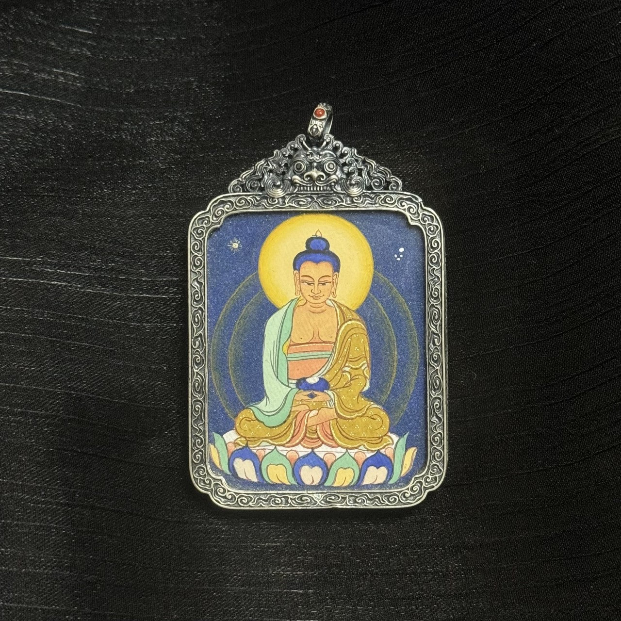 Full view of Amitabha Buddha mini thangka pendant, hand-painted in Tibet with mineral pigments, enclosed in an ornate vintage silver frame.