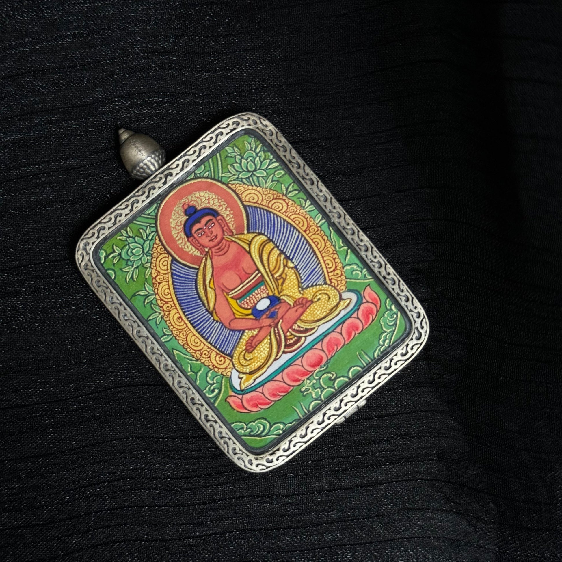Top perspective of Amitabha Buddha thangka pendant displaying the full hand-painted composition, lotus throne and decorative silver pendant frame