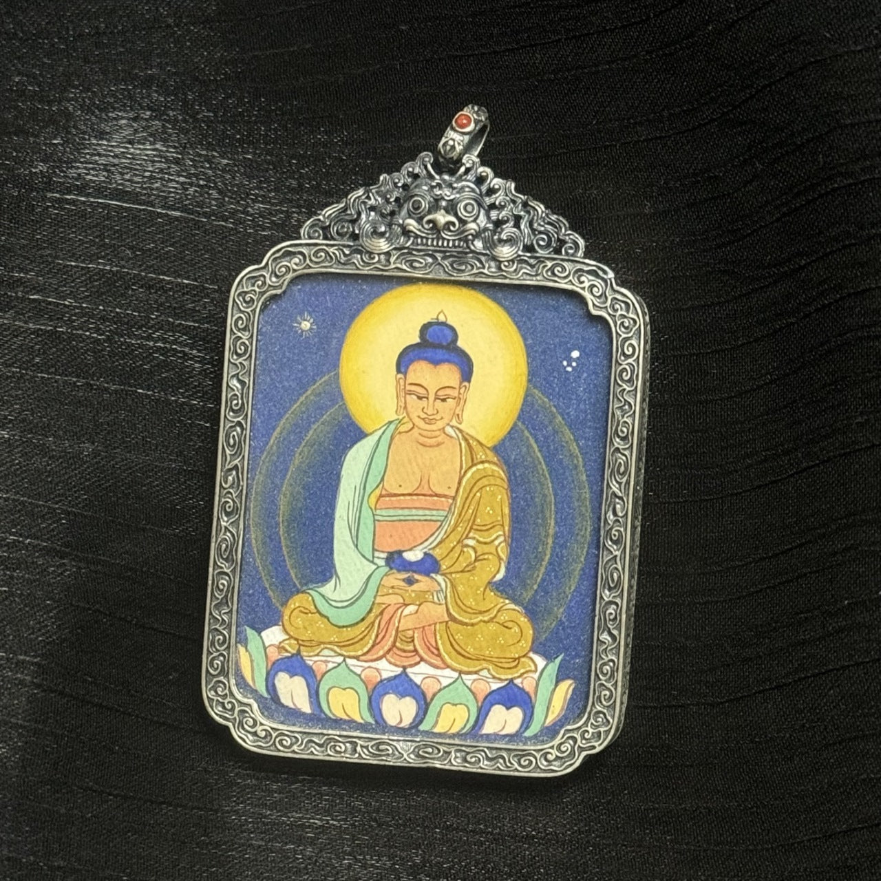 Detailed view of the vintage silver case of the Amitabha Buddha thangka pendant, highlighting traditional metalwork and protective structure.