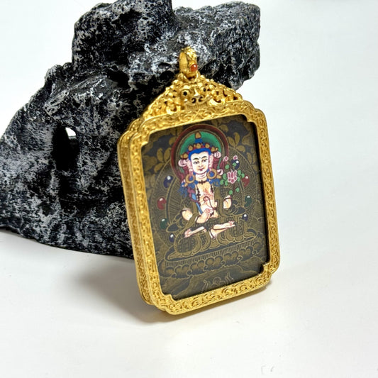 Angled view of Akasagarbha Bodhisattva mini thangka pendant showing layered black gold painting surface, gold accents, and finely detailed copper frame