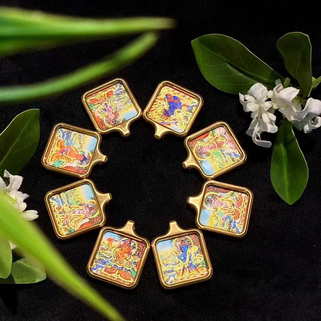 Assorted gold-accented Tibetan thangka pendants in square gau box format, suitable for wholesale and bulk supply