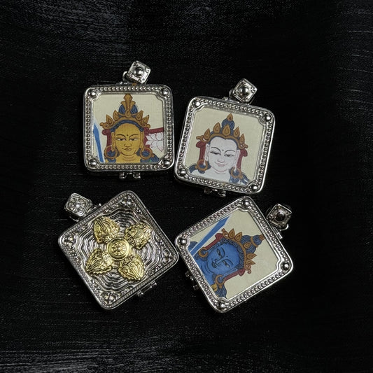 Four square mini thangka pendants on a black textured background, showing three single-sided hand-painted bodhisattva portraits in silver-tone frames with beaded edging and rounded corner beads, plus one pendant back with a raised gold-tone vajra motif over a wavy textured metal panel