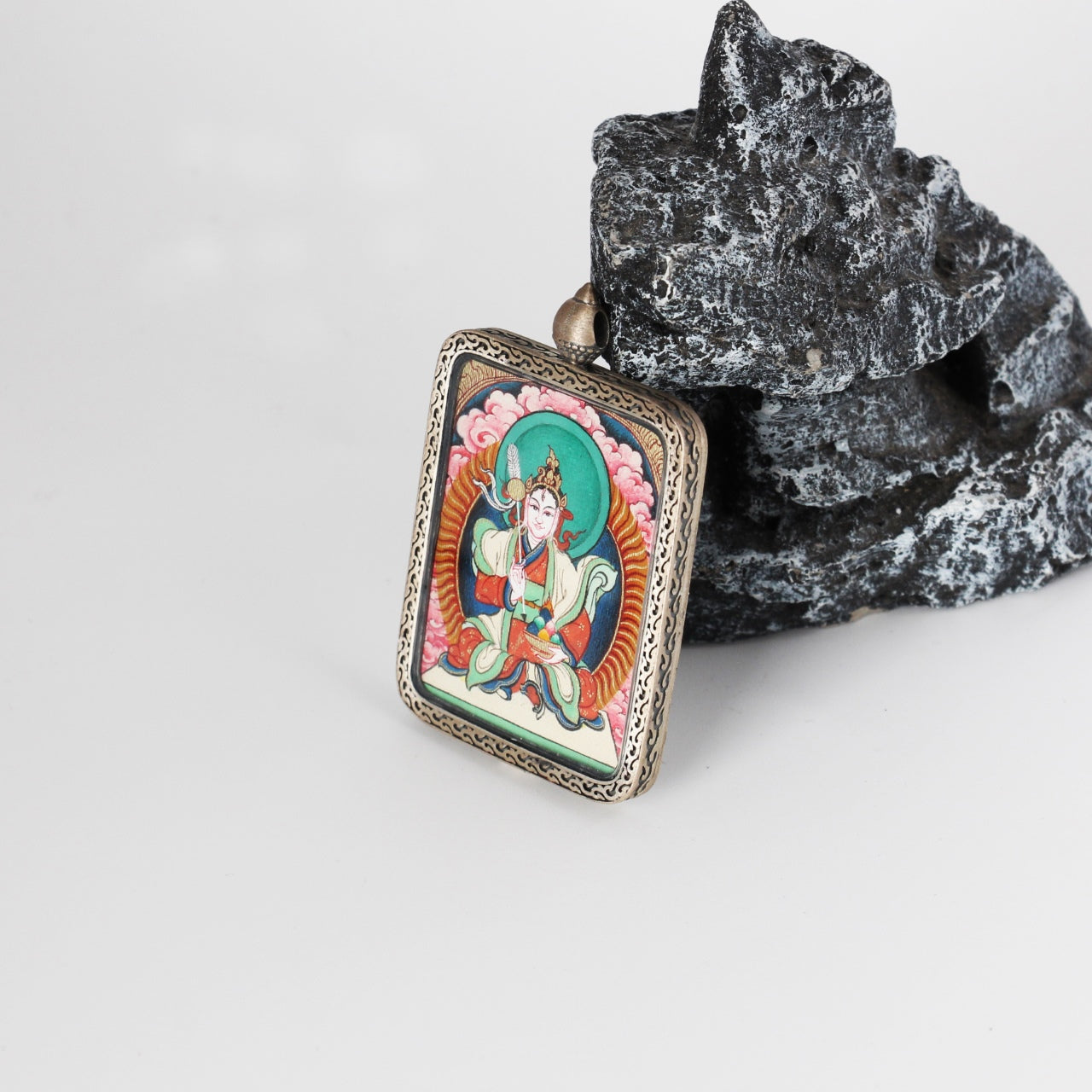 Side profile of Bai Lhamo mini Thangka pendant highlighting the thickness of the silver case, fine metal craftsmanship, and the mounted hand-painted Thangka artwork.