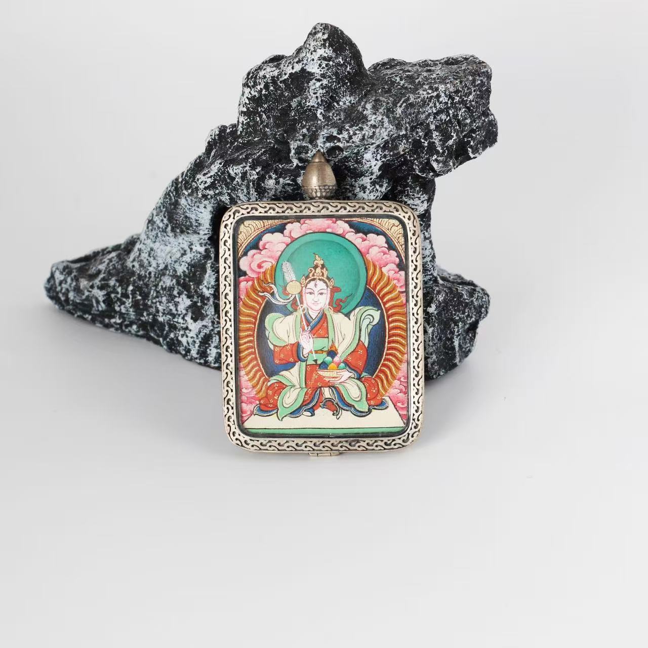 Front view of Bai Lhamo mini Thangka pendant, hand-painted with mineral pigments, mounted in a pure silver case with traditional Tibetan decorative patterns.