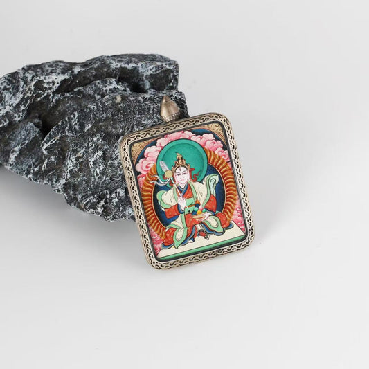Angled view of Bai Lhamo Tibetan mini Thangka pendant showing hand-painted deity details, mineral pigment layering, and engraved silver frame inspired by the Dunhuang Nine-Colored Deer motif.
