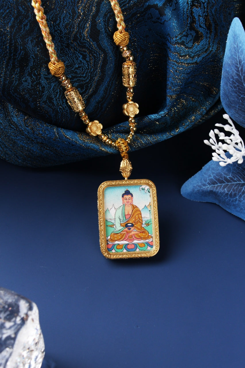 Close-up of Amitabha Buddha mini thangka pendant highlighting the hand-painted facial details, lotus seat colors, and textured rectangular metal frame