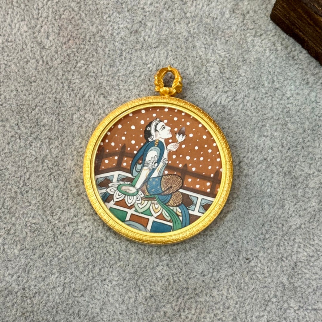 Close-up view of the Holding Lotus Avalokiteshvara mini thangka pendant, focusing on facial expression, lotus detail, and mineral pigment texture within the copper frame.