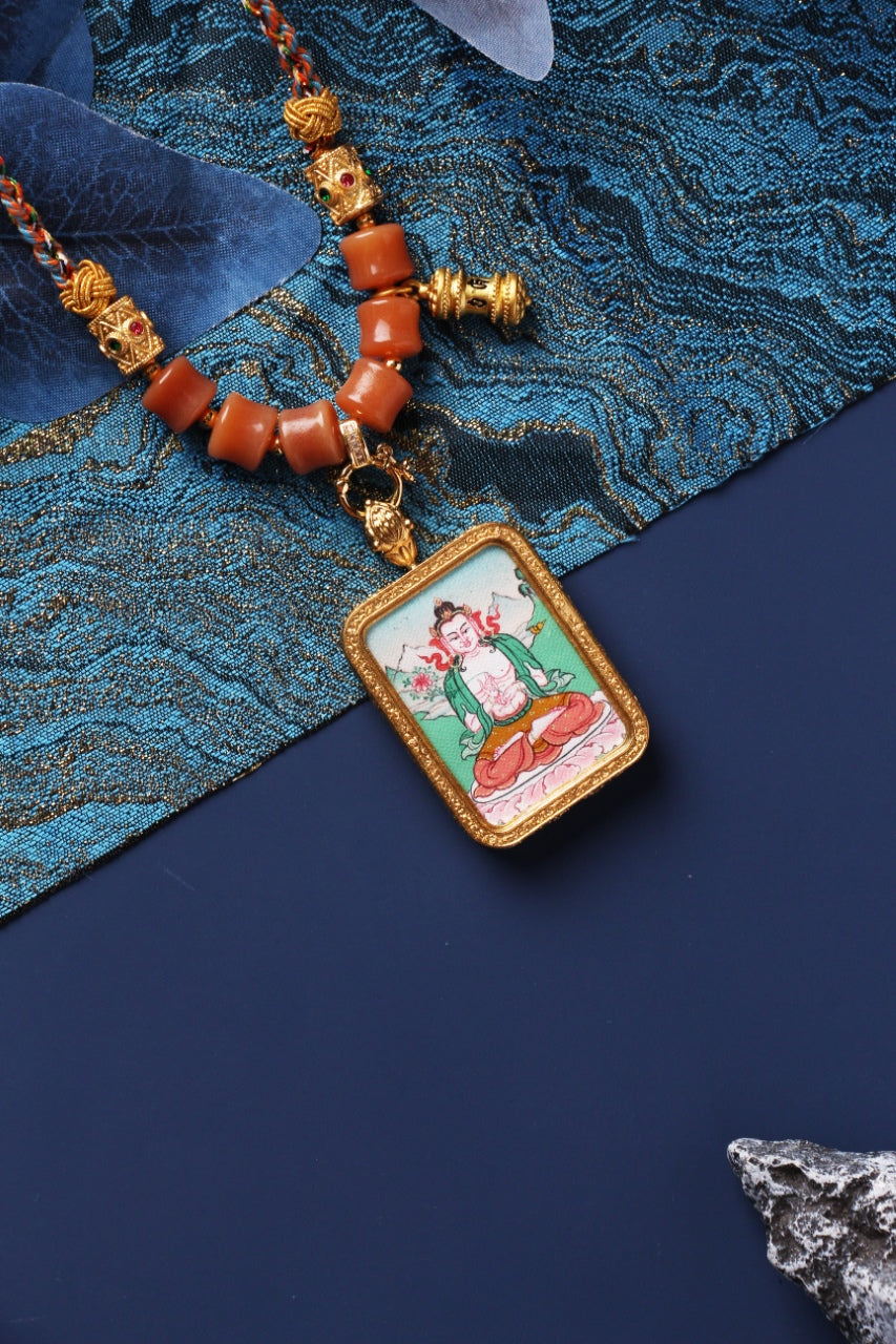 Close-up view of Mahasthamaprapta Bodhisattva mini thangka pendant highlighting the metal frame texture, painted lotus seat colors, braided cord knots, and bead arrangement