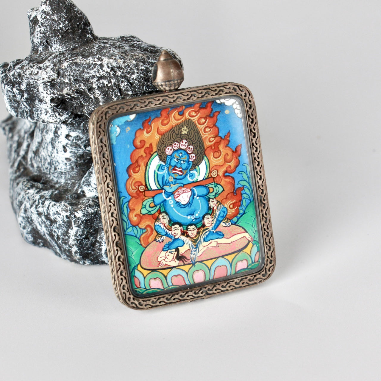 Close-up detail of Bernagchen Black Cloaked Mahakala mini thangka pendant highlighting fine line work, mineral pigment colors, and ornate Dunhuang-inspired silver frame
