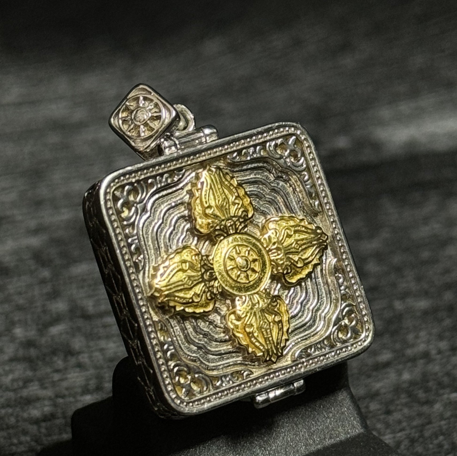 Back view of gawu pendant showing engraved double vajra symbol on metal case used for Tibetan portable shrine pendants