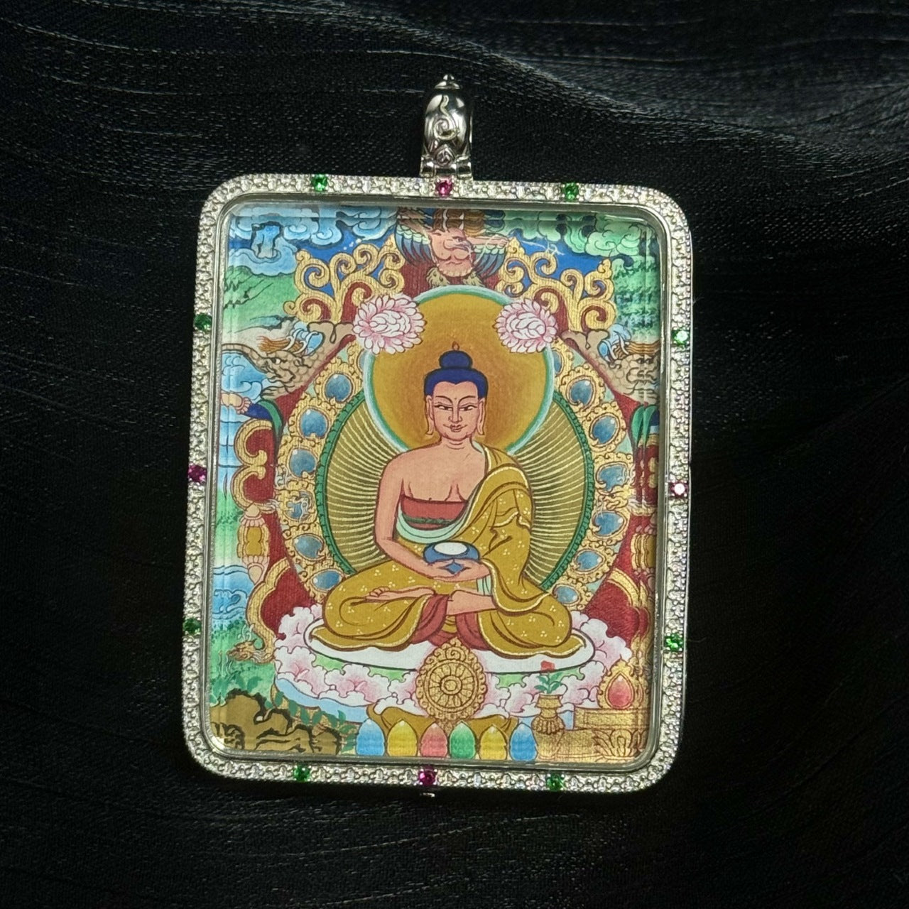 Full frontal composition of Amitabha Buddha mini thangka pendant in a double-sided silver gawu case, displaying seated meditation posture, ritual bowl in hand, ornate Tibetan floral motifs, and multi-color gemstone accents on the frame.