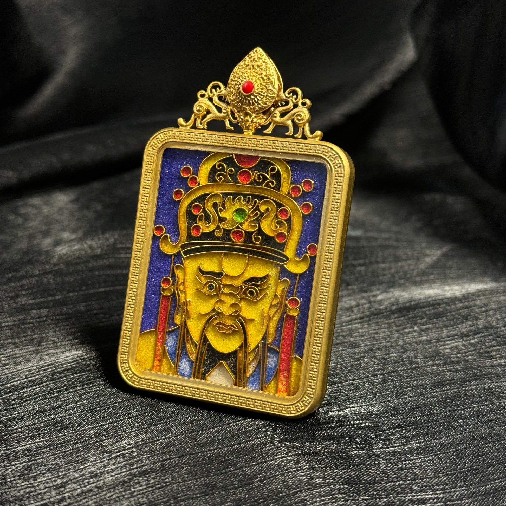 Angled view of Dragon King Wuye cloisonné enamel pendant showing raised gold-plated copper frame, intricate crown details with red enamel dots, and textured blue cloisonné background.