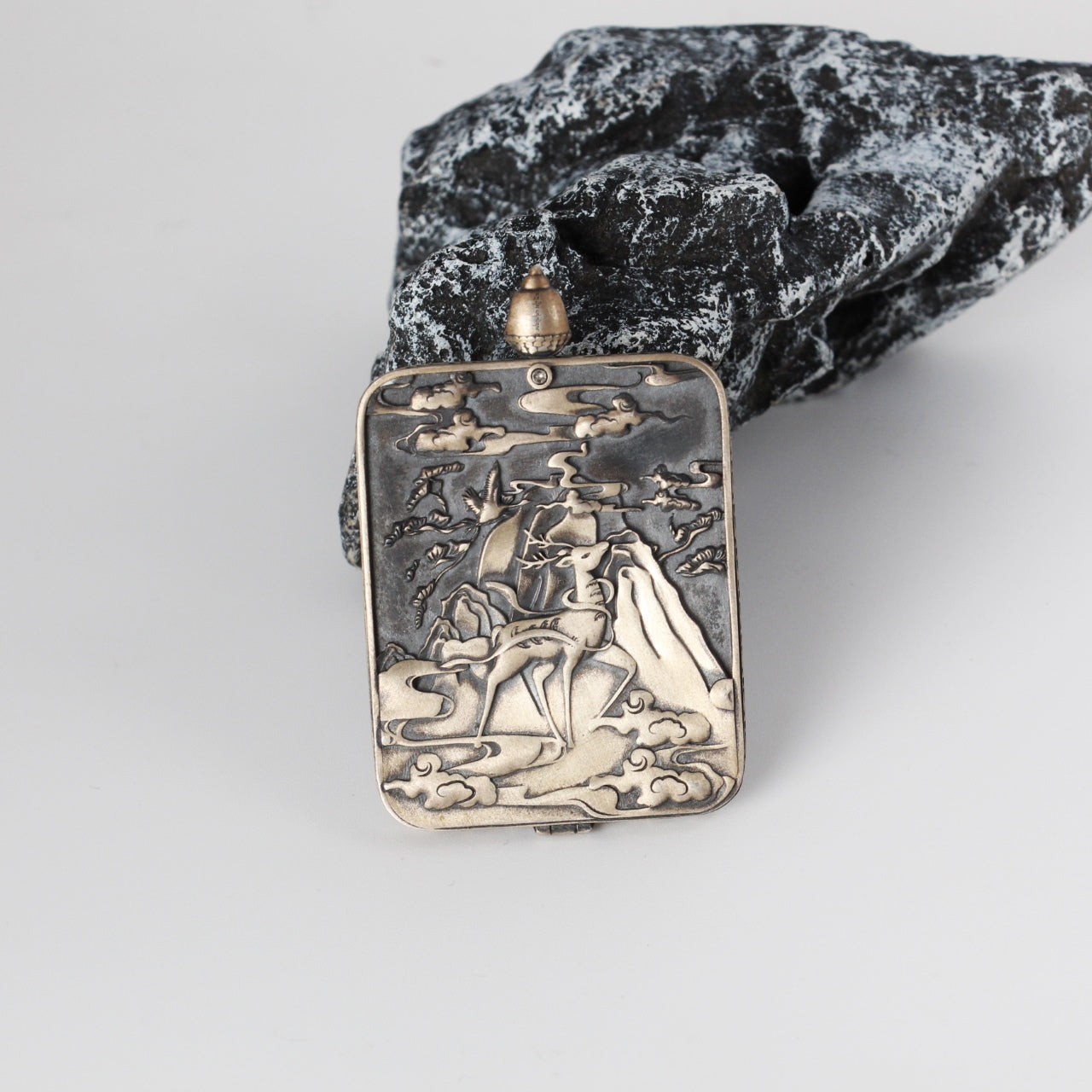 Back view of Green Tara mini thangka pendant showing the Dunhuang Nine-Colored Deer engraved silver case with cloud and mountain motifs
