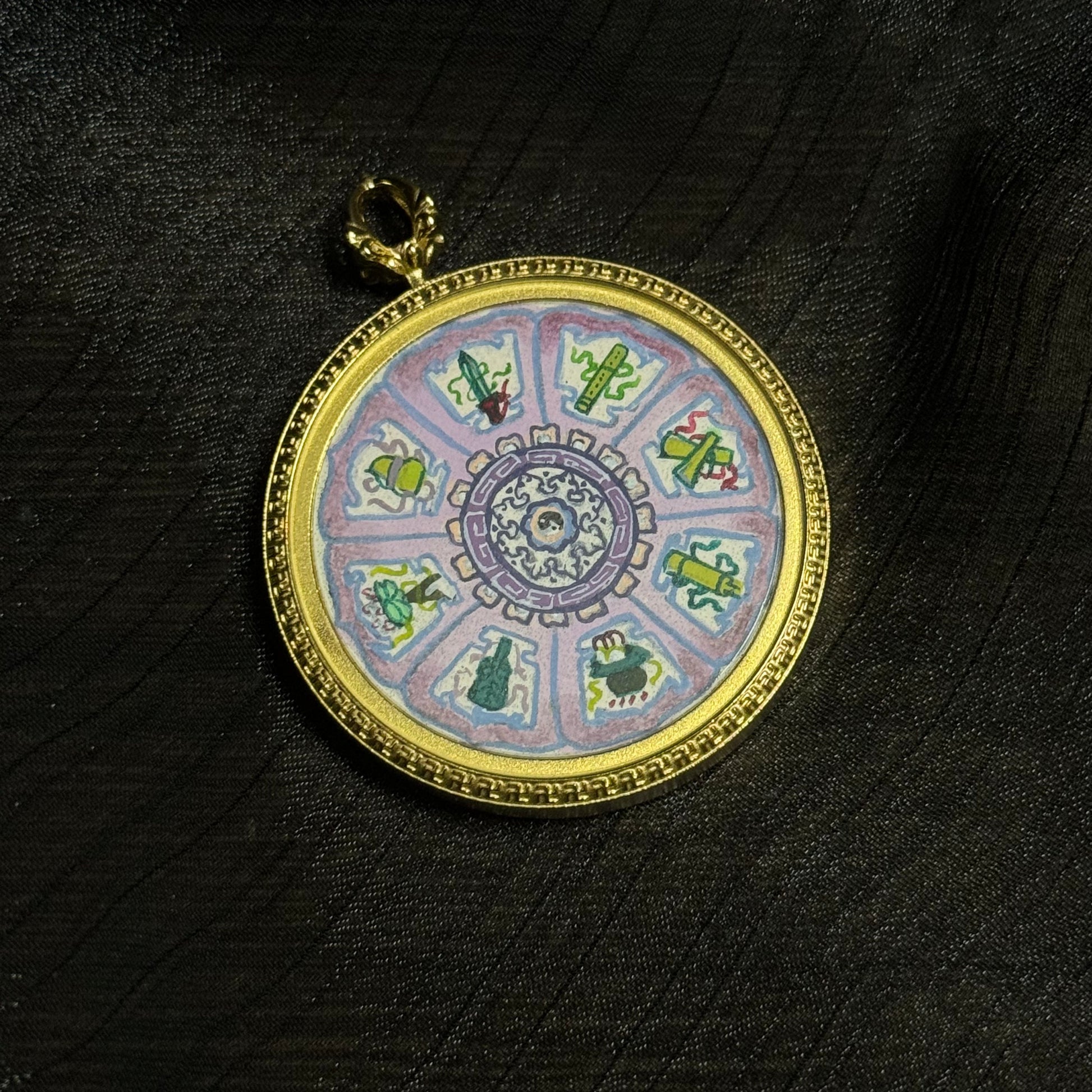 Mini thangka pendant featuring the Eight Immortals sacred symbols arranged in a circular mandala design, hand-painted with colorful mineral pigments and set in a gold-toned pendant frame.