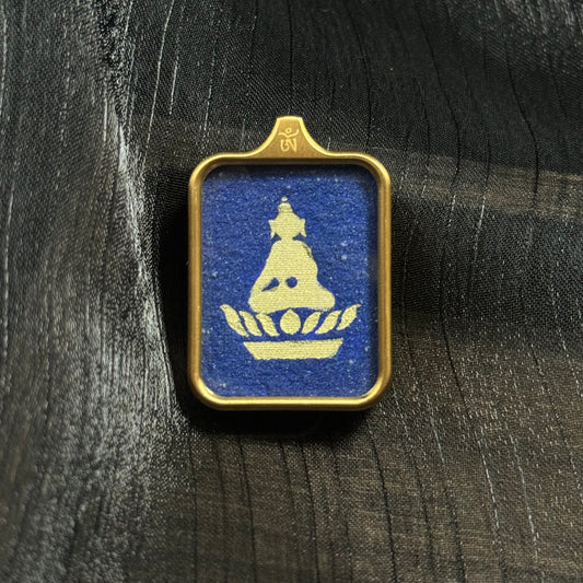 Hand-painted Formless Buddha mini thangka pendant from Rebgong featuring a minimalist Buddha silhouette painted with gold powder on a deep blue lapis lazuli mineral pigment background inside a rectangular metal frame.