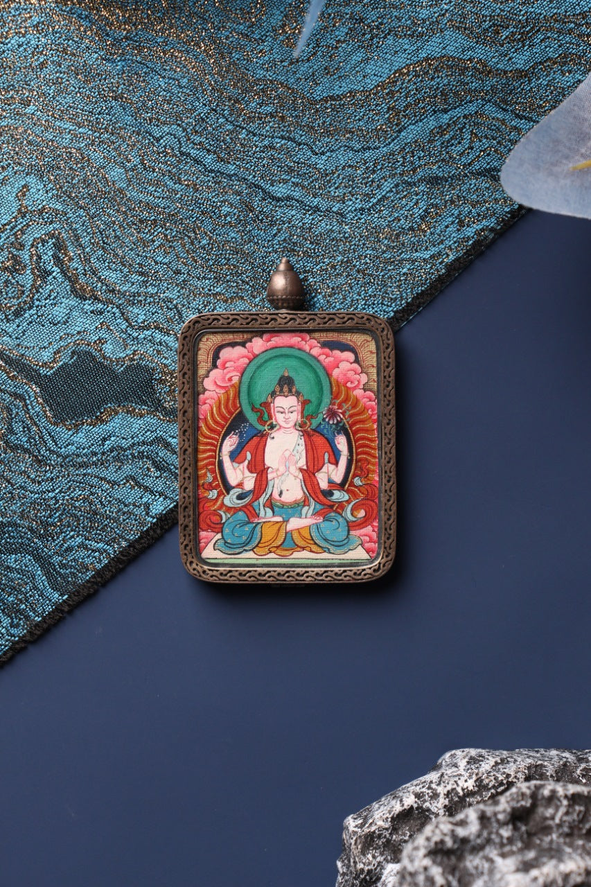 Front view of a Four-Armed Avalokiteshvara mini thangka pendant from Tibet, hand-painted with mineral pigments and housed in a pure silver gawu-style case.